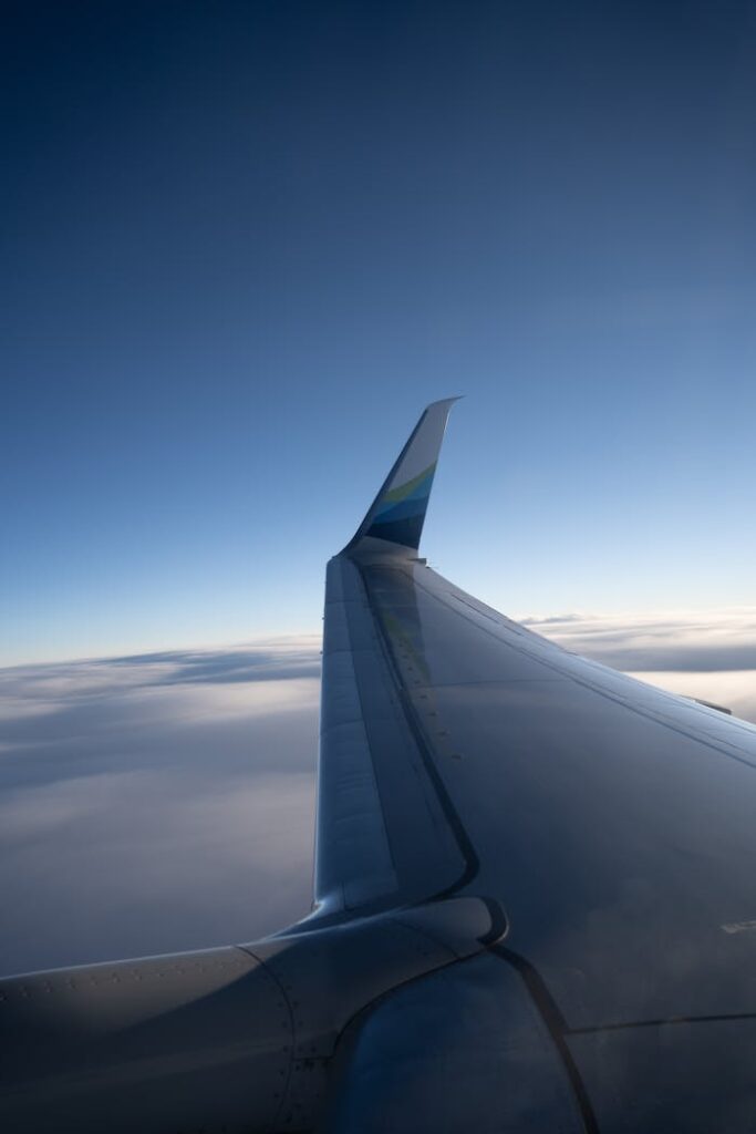 an-airplane-wing-is-seen-from-above-the-clouds-27798139 An airplane wing is seen from above the clouds